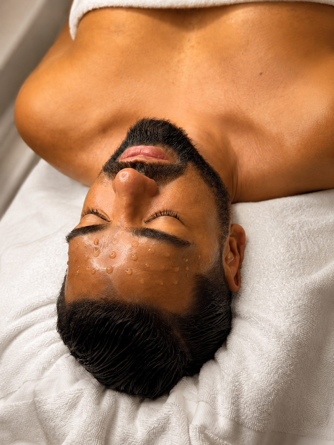 Hombre recibiendo un facial personalizado con luz cálida natural